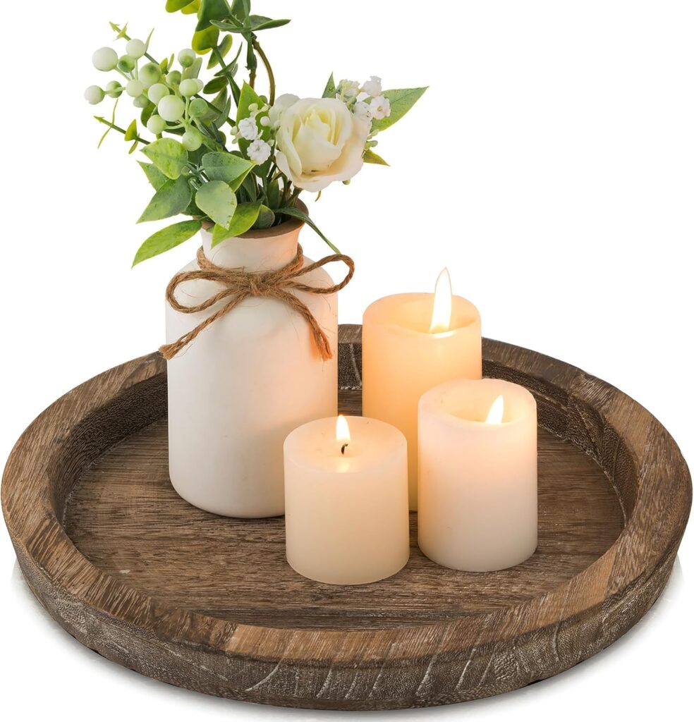 A round, minimalist beige ceramic tray holding a white candle and small gold trinkets, used for home organization.