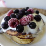 Oat banana pancakes topped with fresh berries and yogurt