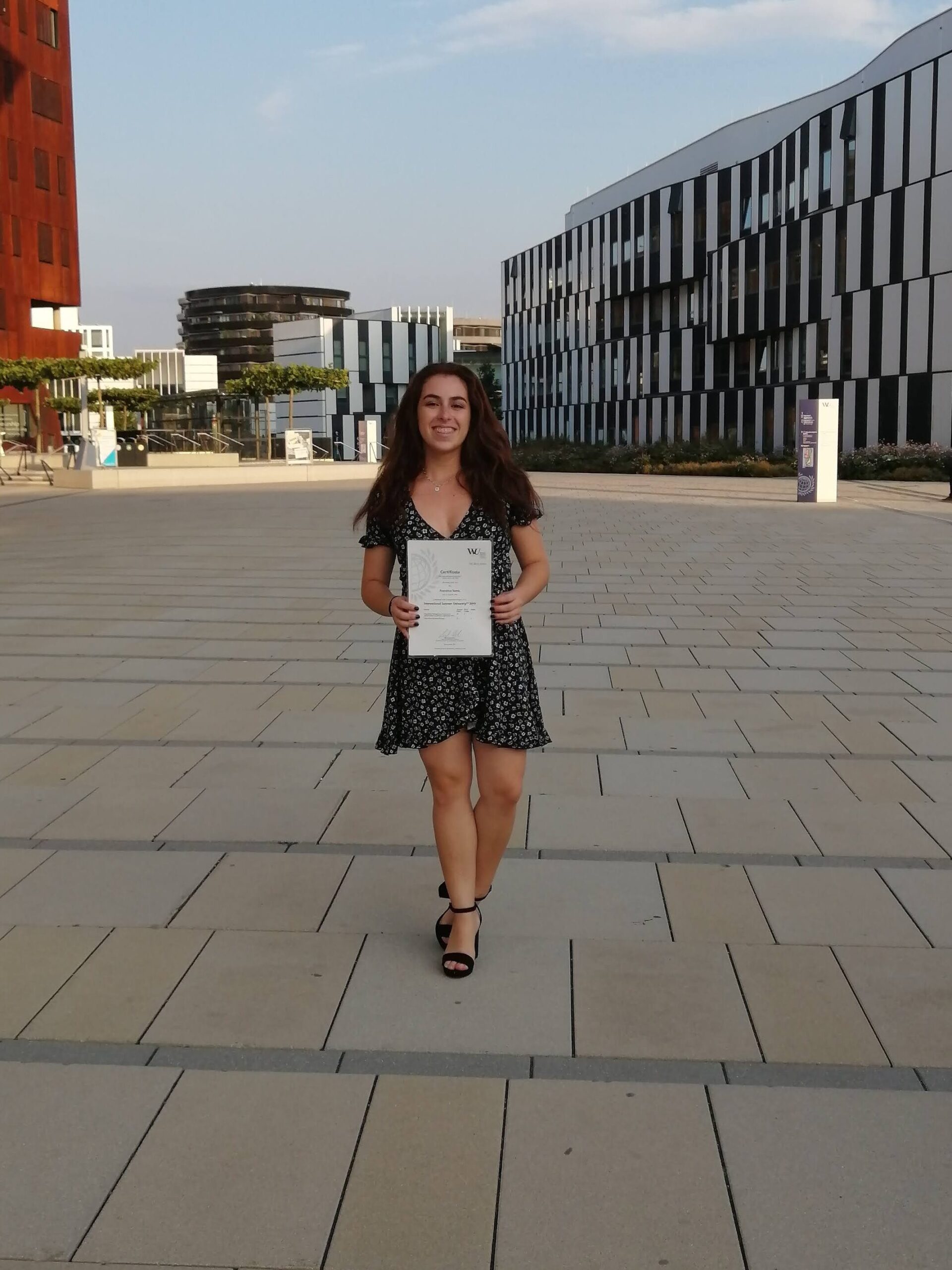 Traveler holding certificate in a modern plaza