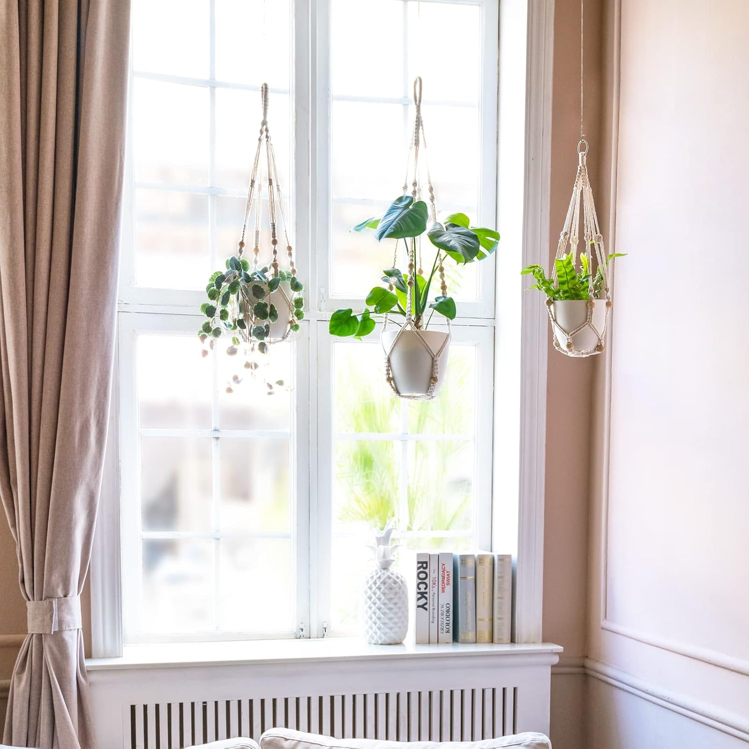 Woven macrame hanging planter with an ivy plant near a window.